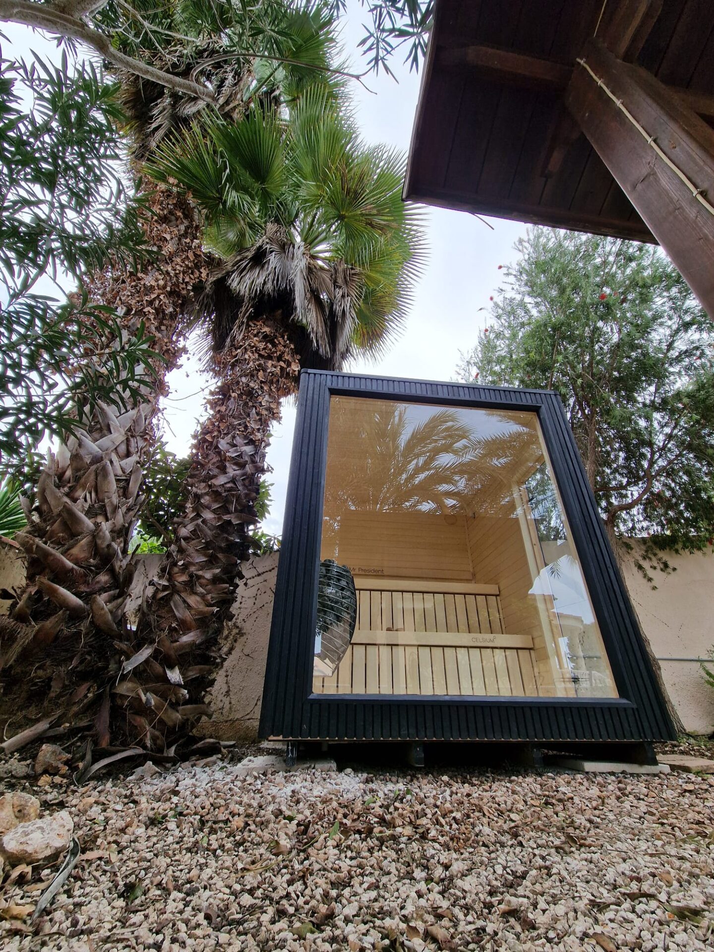 A modern Celsium Wellness sauna surrounded by lush greenery and calm outdoor living