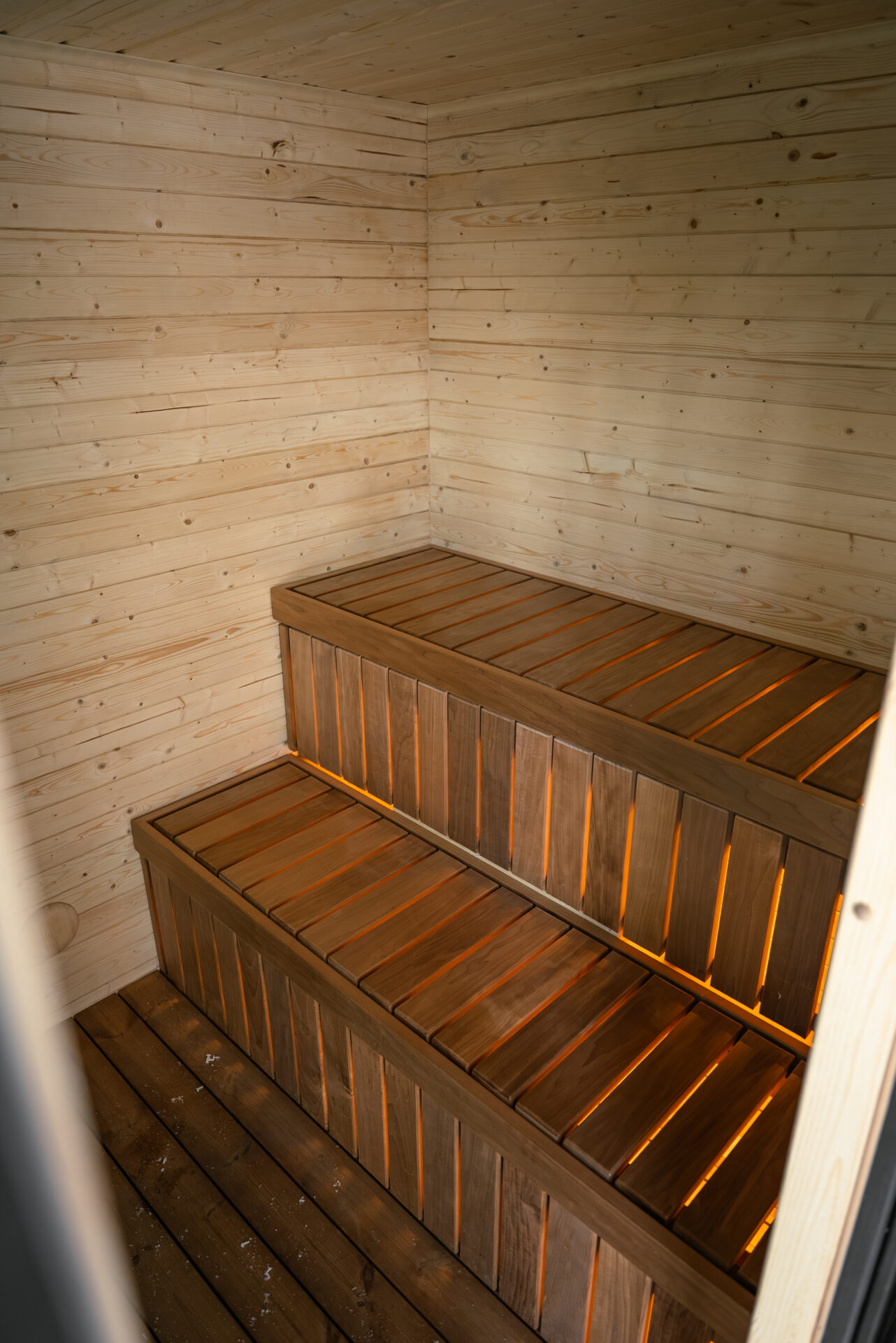 Quite modular sauna resting in a winter forest, designed for slow outdoor wellness